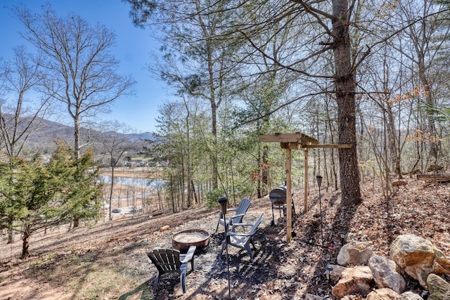 view of yard featuring a mountain view and a fire pit