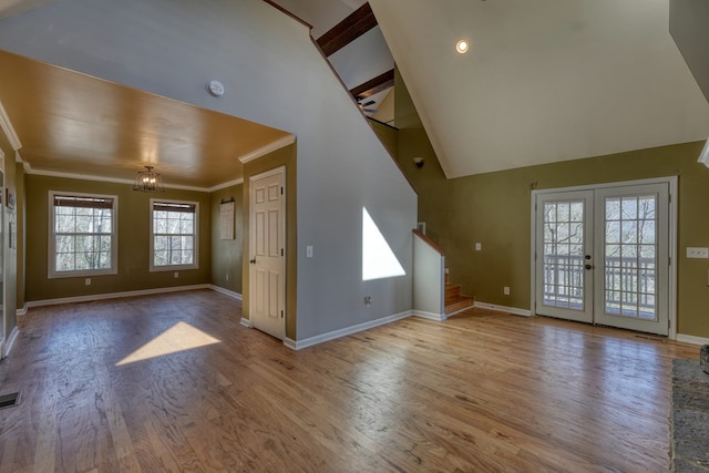 entryway featuring baseboards, ornamental molding, wood finished floors, stairs, and french doors