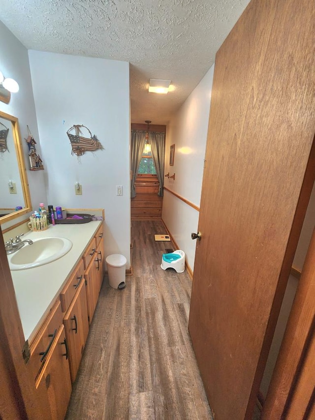 bathroom with vanity, hardwood / wood-style floors, and a textured ceiling