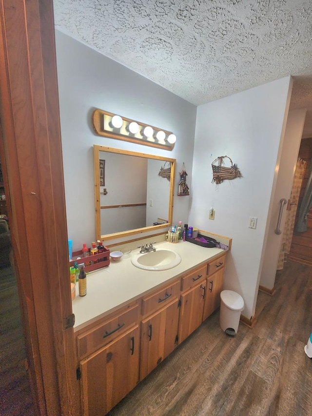 bathroom featuring vanity, hardwood / wood-style floors, and a textured ceiling