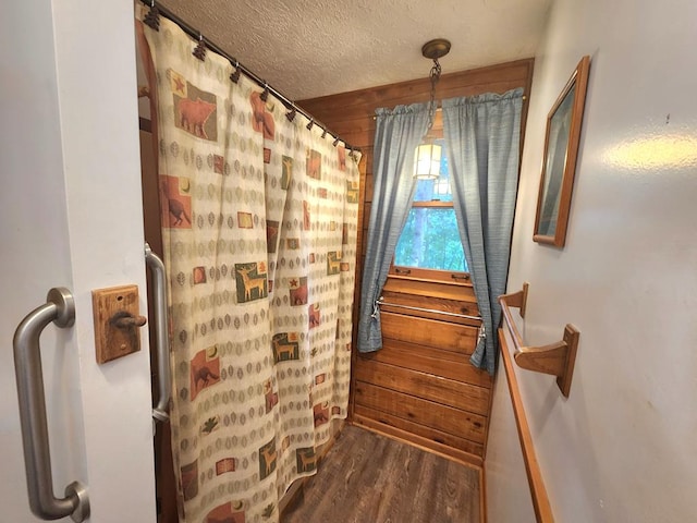 bathroom with hardwood / wood-style flooring, a textured ceiling, and a shower with shower curtain