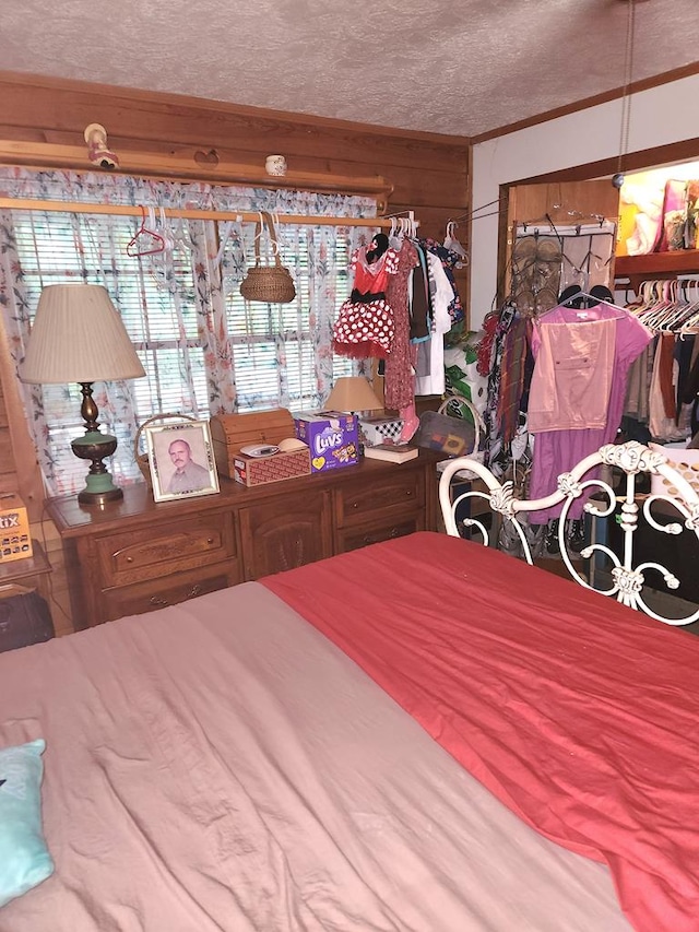 bedroom with a textured ceiling and wood walls