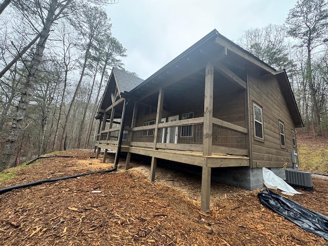 view of property exterior with central air condition unit and a shingled roof