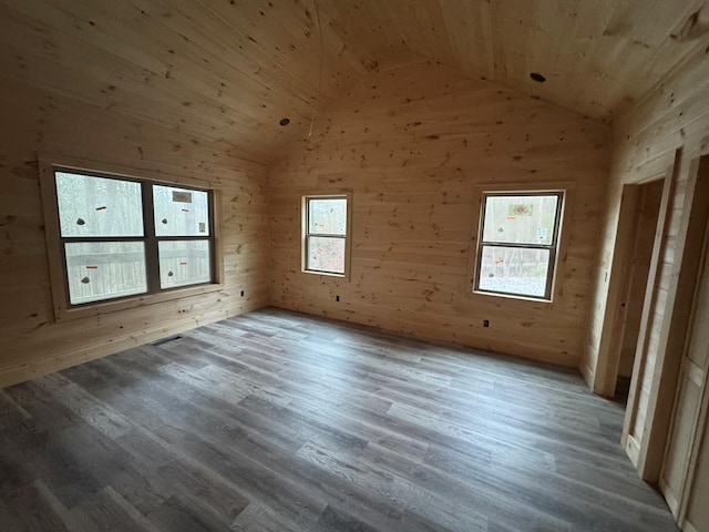 empty room featuring lofted ceiling, wooden ceiling, and light wood-type flooring