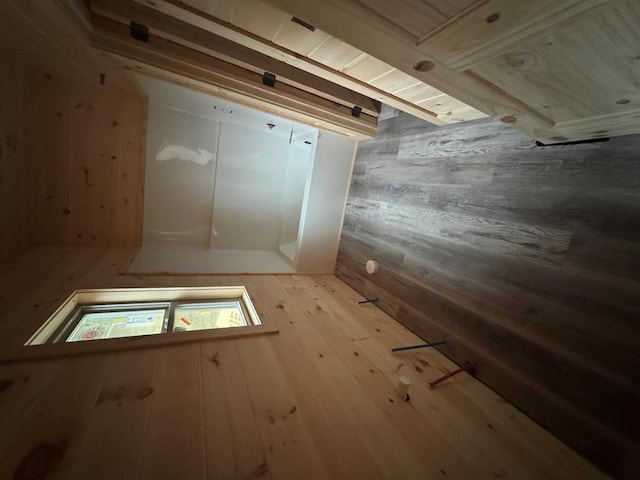 interior space with light wood-type flooring and wood walls