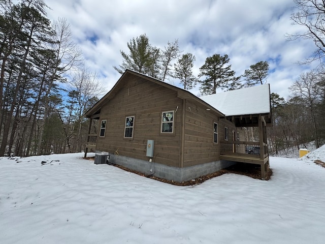 view of snow covered exterior with cooling unit