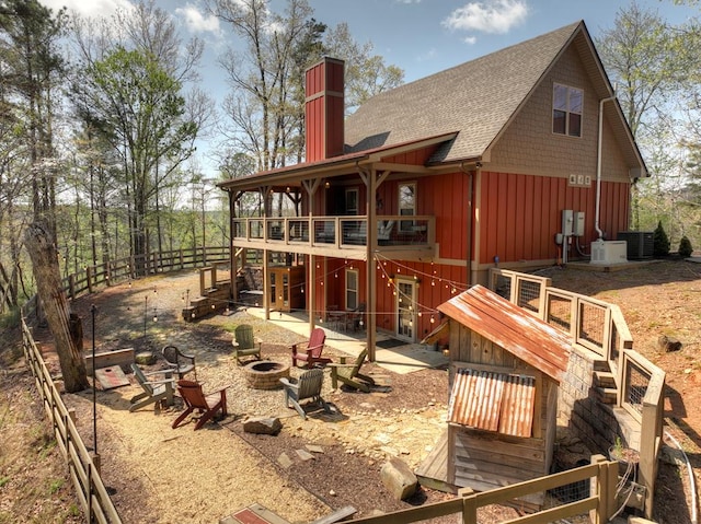 back of house with a patio, a chimney, a fire pit, central AC, and a shingled roof