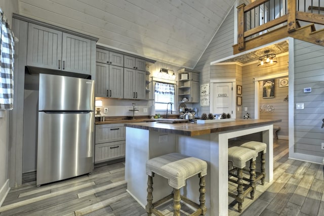 kitchen with wood counters, light wood-style floors, freestanding refrigerator, and gray cabinets