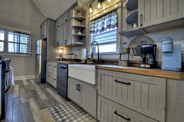 kitchen with a sink, open shelves, plenty of natural light, and stainless steel appliances