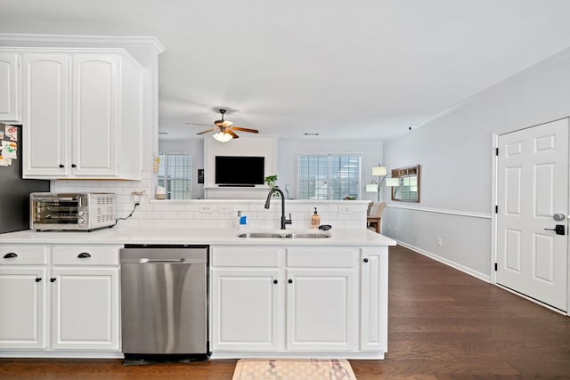 kitchen featuring dark wood-style flooring, a toaster, a sink, dishwasher, and a peninsula