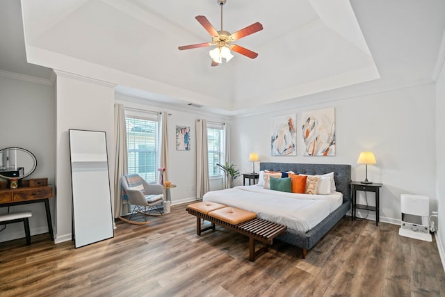 bedroom featuring baseboards, a raised ceiling, and wood finished floors