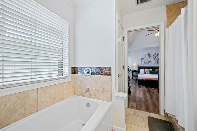 ensuite bathroom with a garden tub, tile patterned flooring, ornamental molding, and connected bathroom