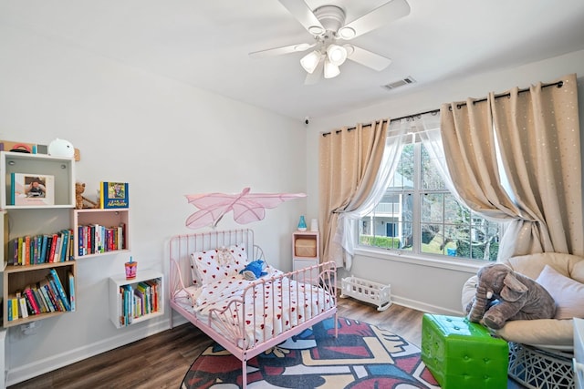 bedroom with a ceiling fan, baseboards, visible vents, and wood finished floors