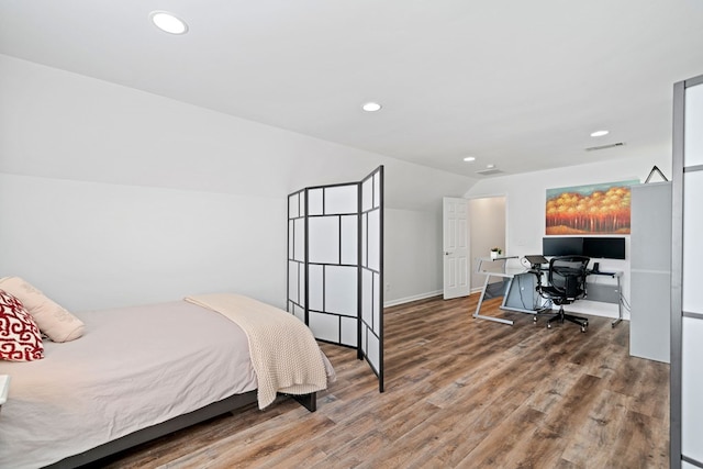 bedroom with vaulted ceiling, wood finished floors, visible vents, and recessed lighting