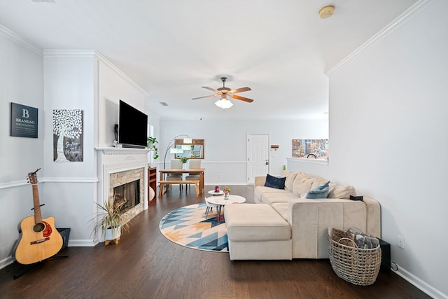 living room featuring ornamental molding, a ceiling fan, a fireplace, and wood finished floors