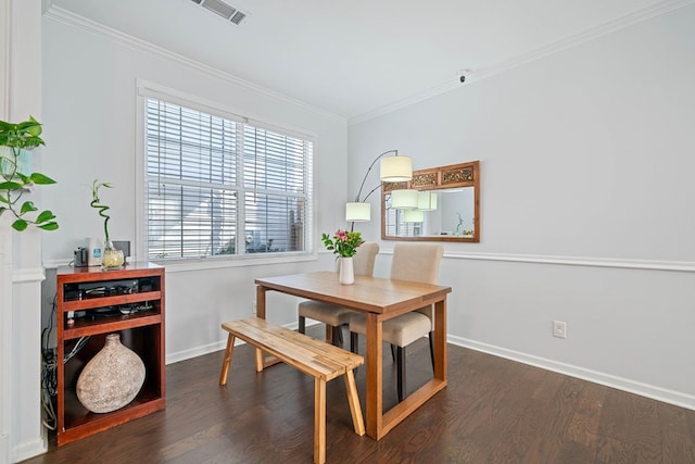 dining area featuring dark wood-type flooring, visible vents, ornamental molding, and baseboards