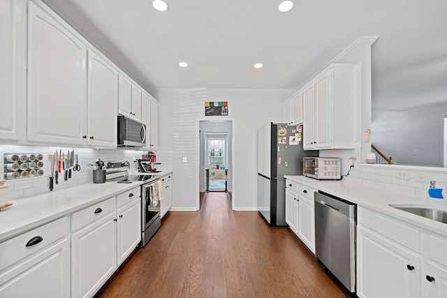 kitchen with recessed lighting, stainless steel appliances, white cabinetry, decorative backsplash, and dark wood-style floors