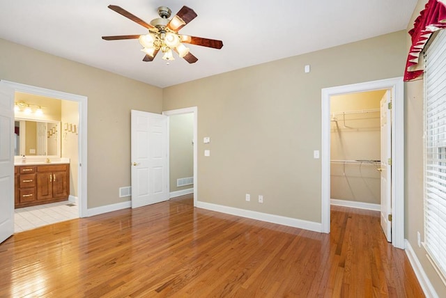 220 Oak Ridge Ln, Ellijay, GA 30536 - unfurnished bedroom with light wood-style flooring, a walk in closet, a closet, ceiling fan, and ensuite bath