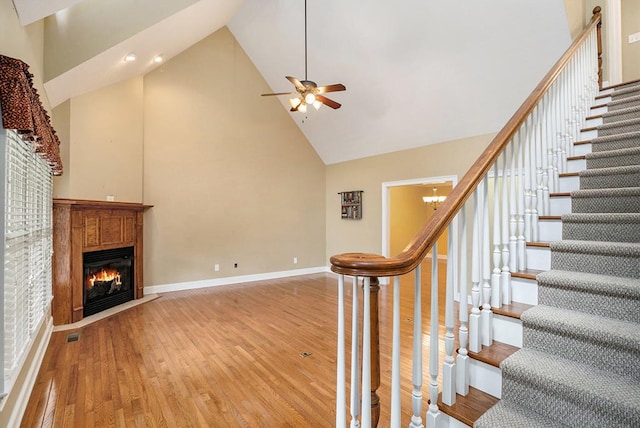220 Oak Ridge Ln, Ellijay, GA 30536 - stairway featuring high vaulted ceiling, ceiling fan, wood finished floors, and a glass covered fireplace