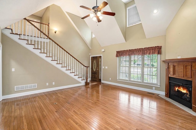 220 Oak Ridge Ln, Ellijay, GA 30536 - unfurnished living room with high vaulted ceiling, stairs, wood-type flooring, ceiling fan, and a fireplace with flush hearth