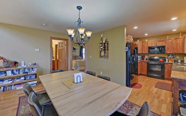 dining area featuring light wood-style floors, recessed lighting, and a chandelier