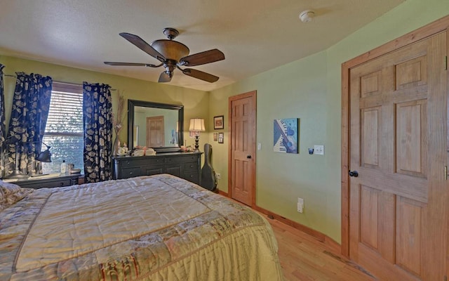 bedroom with baseboards, ceiling fan, and light wood finished floors