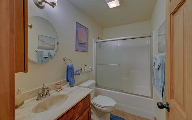 bathroom with enclosed tub / shower combo, vanity, toilet, and tile patterned floors