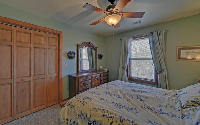 bedroom featuring a closet, visible vents, a ceiling fan, and light colored carpet