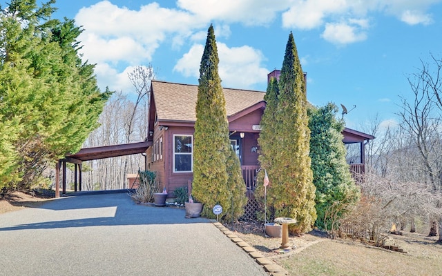 view of front of property with a shingled roof and an attached carport