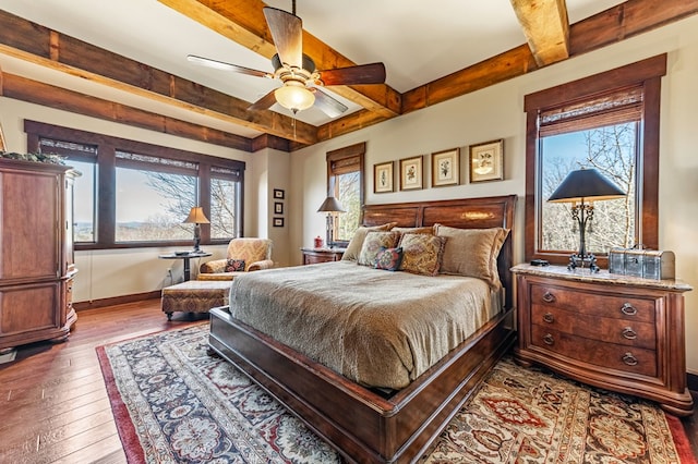 bedroom featuring ceiling fan, beamed ceiling, baseboards, and hardwood / wood-style floors