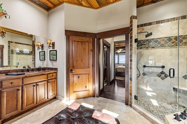 full bathroom with connected bathroom, baseboards, a stall shower, a towering ceiling, and vanity