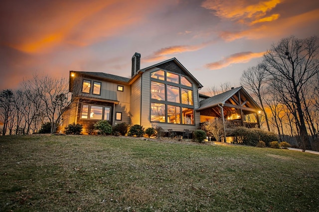 back of property featuring a lawn and a chimney