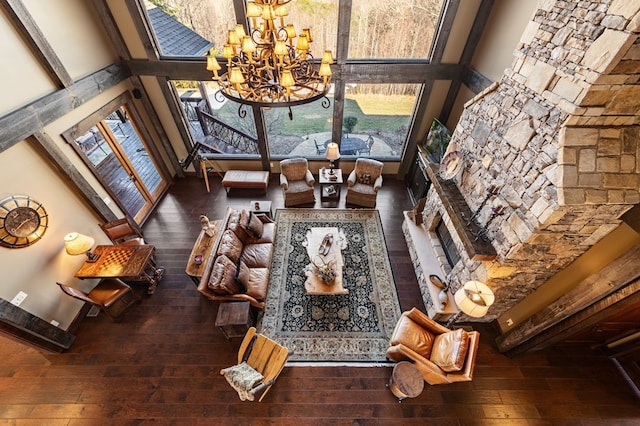 living area with an inviting chandelier, a high ceiling, and hardwood / wood-style flooring