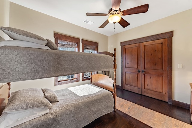 bedroom with dark wood-type flooring, baseboards, visible vents, and ceiling fan