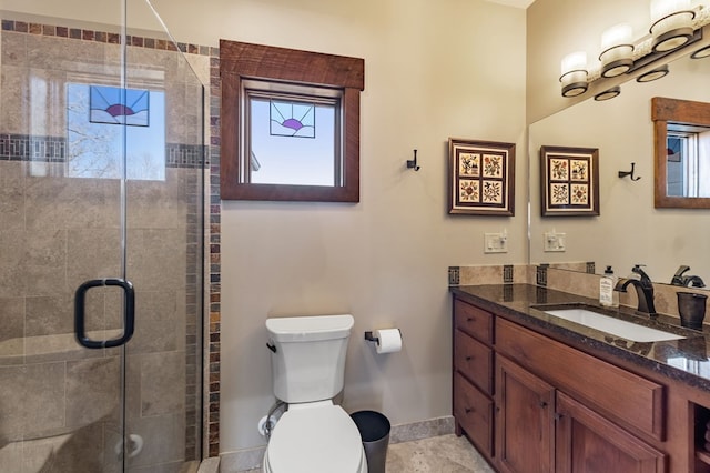 full bath with vanity, toilet, baseboards, and a stall shower