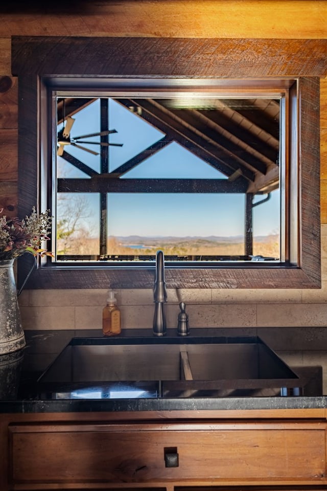 interior space featuring a sink, dark countertops, and vaulted ceiling with beams