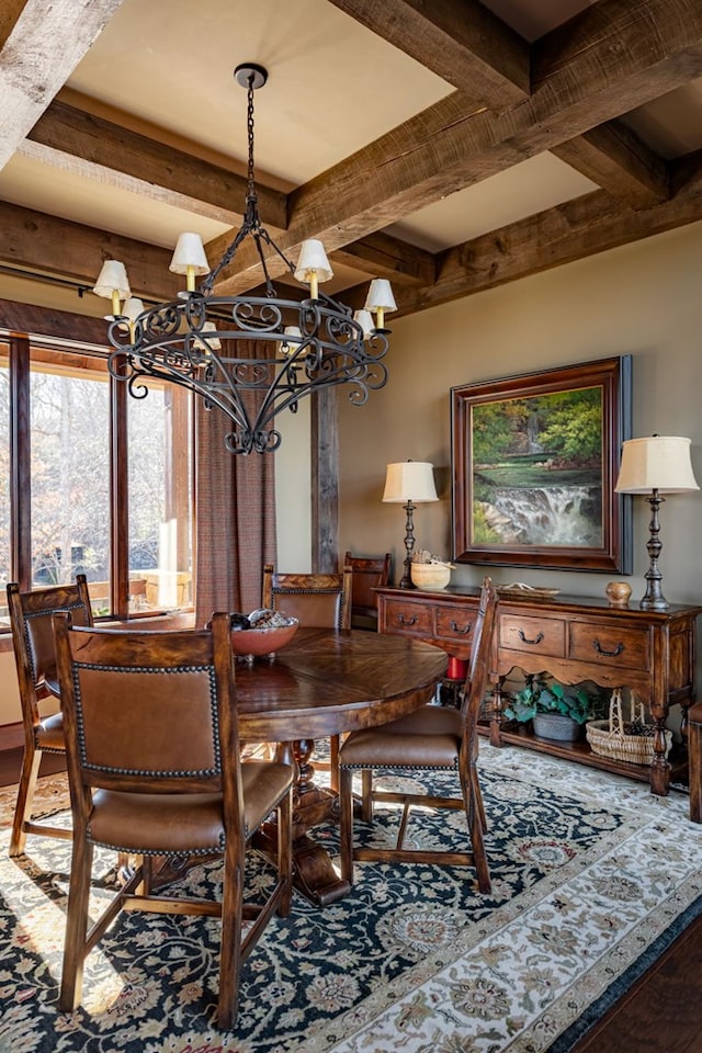 dining area with beamed ceiling, an inviting chandelier, and wood finished floors