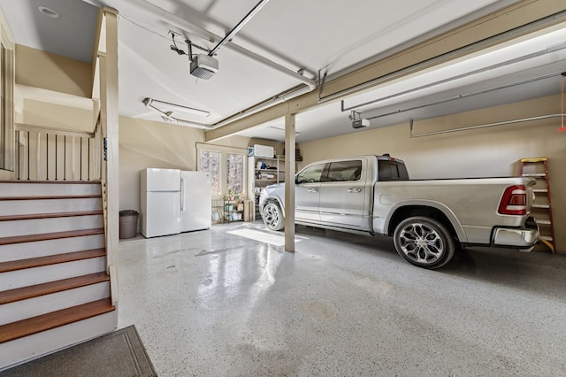 garage featuring a garage door opener and freestanding refrigerator