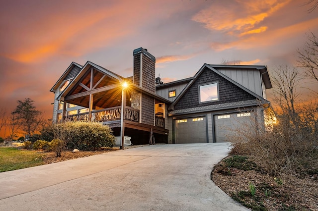 view of front of property with a chimney, concrete driveway, and a garage