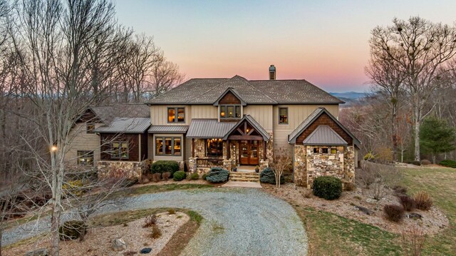 view of front of property featuring stone siding and a chimney