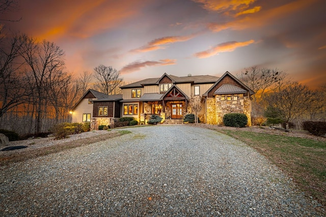 view of front of property featuring stone siding and driveway