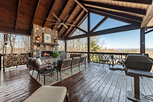 deck featuring an outdoor living space with a fireplace and a ceiling fan