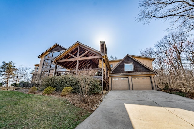 view of front of property with a front yard, a garage, driveway, and a chimney