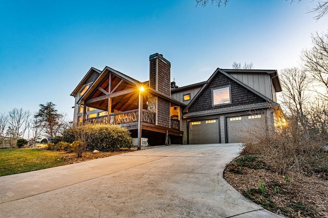 view of front of house featuring concrete driveway, an attached garage, and a chimney