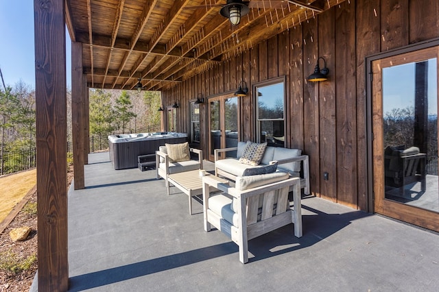 view of patio / terrace with fence and a hot tub
