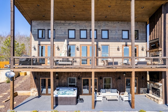 rear view of house with an outdoor hangout area, a patio, a hot tub, and french doors
