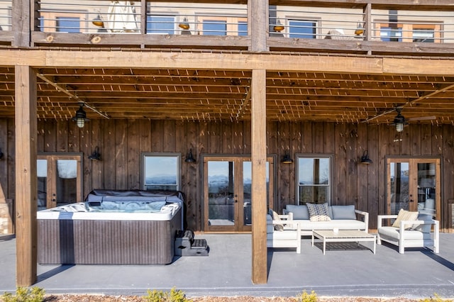 view of patio / terrace featuring outdoor lounge area, a hot tub, a balcony, and french doors