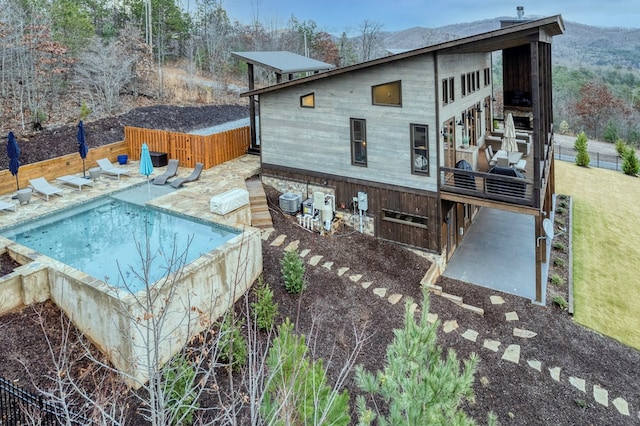 back of property featuring a fenced in pool, fence, central AC unit, and a deck