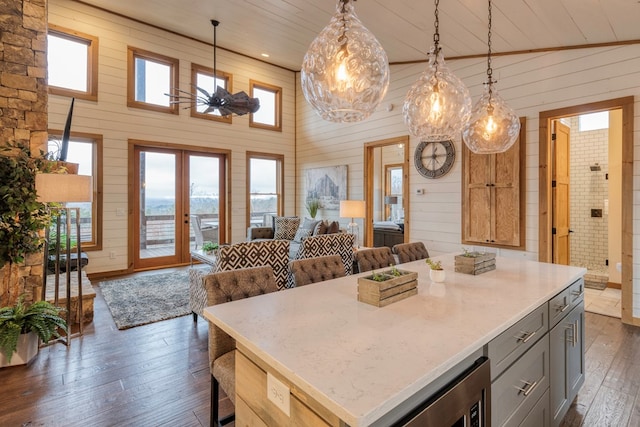 kitchen with open floor plan, gray cabinets, dark wood-style floors, and wooden walls