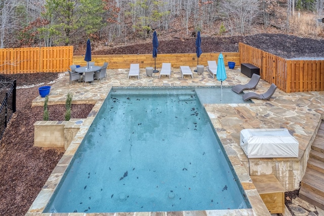 view of swimming pool with a patio area and fence